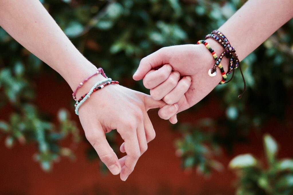 zwei Personen Hände halten Edelstein Armband Schmuckstücke mit besonderer Bedeutung